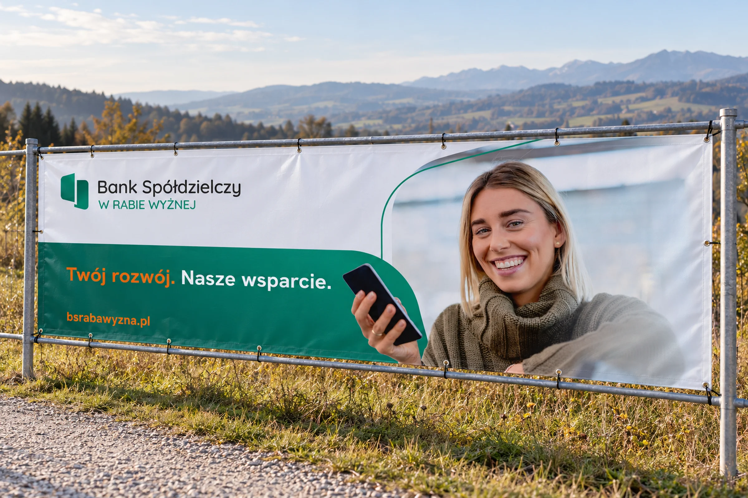 Baner banku 3 x 1 m na ogrodzeniu, w tle podhalański krajobraz i Tatry