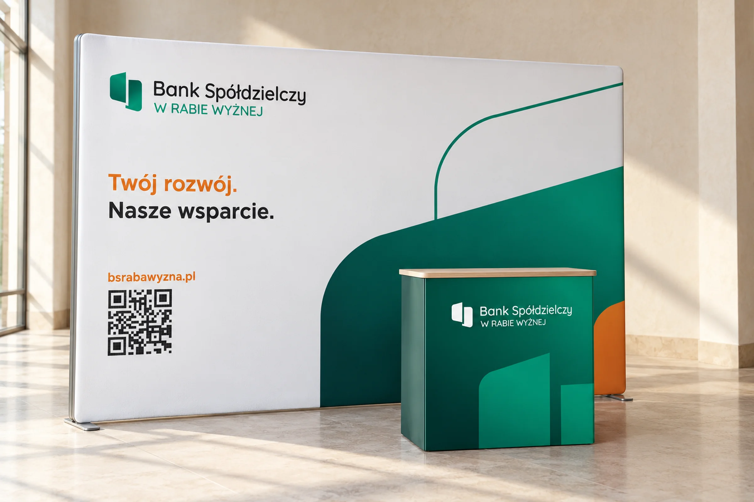 Ścianka wystawiennicza banku z hasłem „Twój rozwój. Nasze wsparcie.” i kodem QR oraz zielona lada z logo